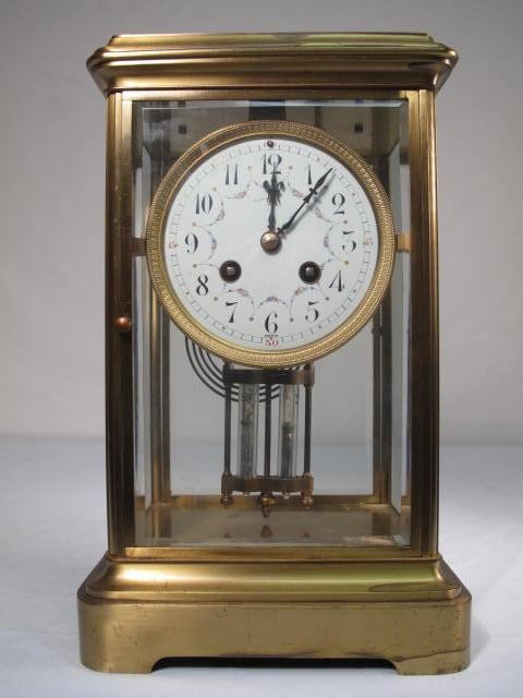 TIFFANY & CO. CRYSTAL REGULATOR MANTLE CLOCK: Tiffany & Co. crystal regulator style mantle or shelf clock. Brass and glass case. Double mercury pendulum. Enameled metal dial with floral design signed Tiffany & Co. at 12 o'clock. Time and strike m