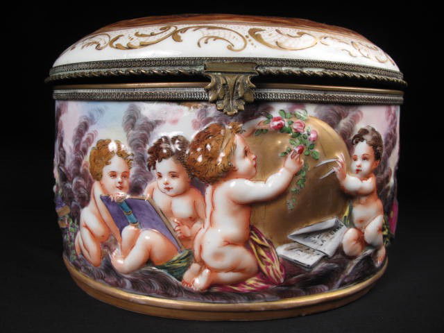 CAPODIMONTE PORCELAIN JEWELRY CASKET: Capodimonte jewelry casket. Italian, painted, depicts nude cherubs. Brass mounts. Gilt along the bottom edge. Also painted inside lid and in bottom of casket with floral decorations. Marked on bottom