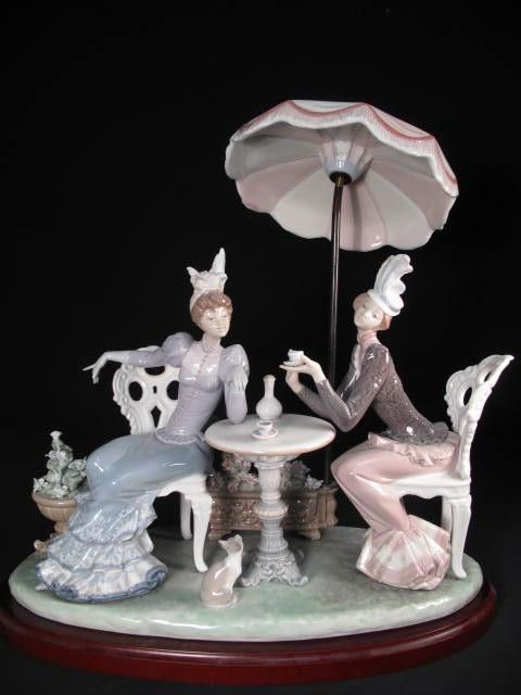 LLADRO PORCELAIN FIGURE: "CAFÉ DE PARIS" # 1511: Lladro porcelain figure. "Cafe de Paris", #1511. On wooden base. Marked "Lladro" on bottom and stamped "1511". Condition: small loss to one flower petal and leaf, see images. Measures 15.25" tall x 14