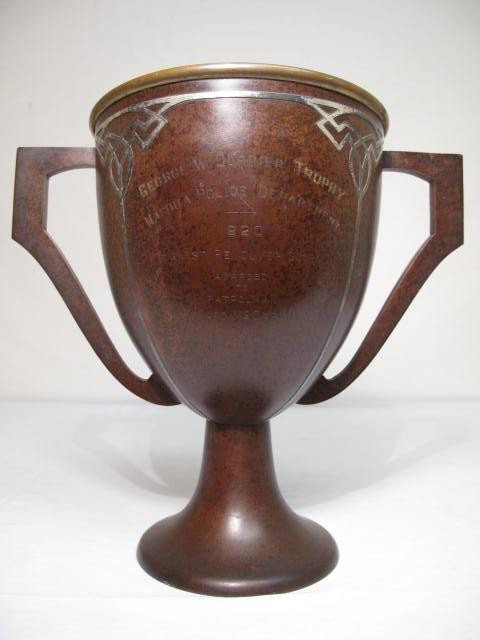 HEINZ MIXED METAL LOVING CUP TROPHY VASE: Heinz mixed metal loving cup trophy vase. Front reads "George W. Currier Trophy Nashua Police Department 1920, Highest Revolver Score Awarded to Patrolman Edward McCarthy". Silver design over bronze. 