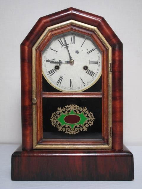 NEW HAVEN MAHOGANY STRIKING SHELF CLOCK: New Haven mahogany striking shelf clock. Reverse painted glass on door. Some crackling, wear to clock face, wood, see images. Measures 15.25" tall x 10.5" wide x 4.5" deep. Shipping weight 3.4 lbs.