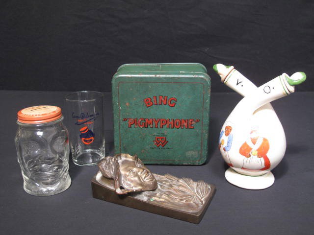 GROUP LOT BLACK AMERICANA: Group lot of five black Americana pieces. Includes a Coon-Chicken Inn juice glass, brass figural inkwell, a Lucky Joe bank figural bank, a Bing "Pigmyphone" tin box, and a Vinegar/oil combination bott
