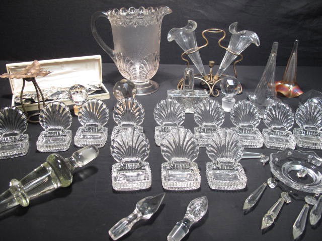 GLASS EPERGNES PITCHER STOPPERS, PRISMS & MORE: Group lot of assorted glass items including a three vase epergne, a single vase epergne, an EAPG pitcher, assorted crystal prisms and a group of pressed glass place holders with salt dip. All in gener