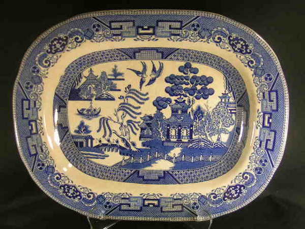 ANTIQUE BLUE WHITE BUFFALO POTTERY BLUE WILLOW PL: ANTIQUE BLUE WHITE BUFFALO POTTERY BLUE WILLOW PLATTER - Semi-Vitregus 1909. Measures 14" long x 11" wide. Crazing and discoloration.