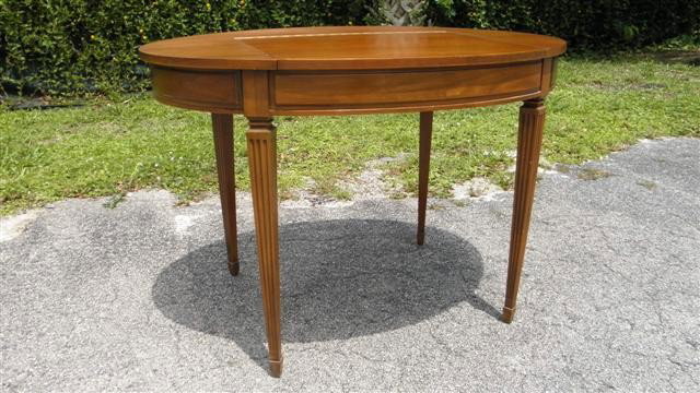 MAHOGANY VANITY TABLE WITH FOLDING MIRROR: Mahogany vanity table with fold down vanity mirror. Oval shape with a lift up front revealing a small mirror & compartments. Fold out drawers on each end as well. Condition: minor wear to finish, see 