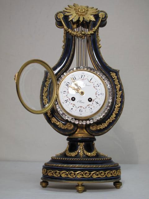 FRENCH COBALT BLUE PASTE-SET LYRE MANTLE CLOCK: An early 20th century French cobalt blue porcelain, paste set, gilt-metal mounted, lyre shape mantle clock with painted enamel dial bearing retail signature for "Festeau Lejeune". Condition: non-worki
