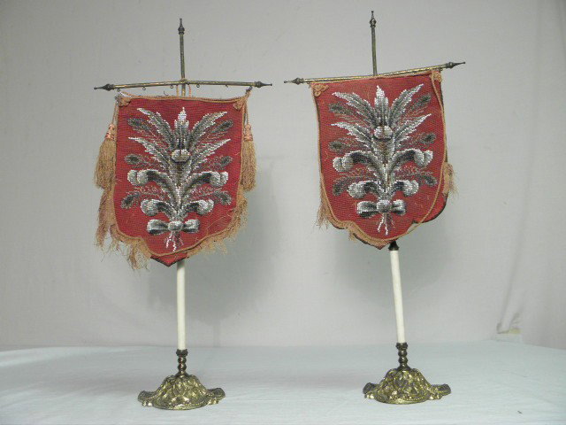 PAIR VICTORIAN BEADWORK FACE HEAT SHIELD SCREENS: Pair Victorian beadwork face heat shield screens. Needlepoint with beads, white, black, grey beads on red background. Supported by brass cross ( with handle) on stand. Condition: tears to fabric from