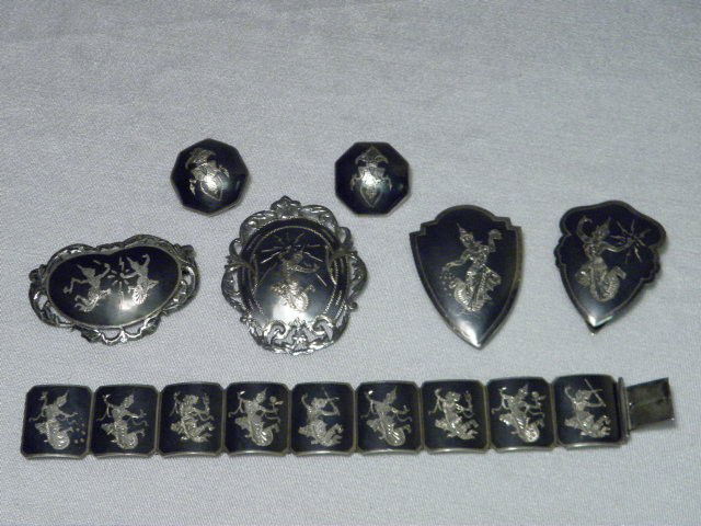 THAI STERLING SILVER JEWELRY GROUP: Thai sterling silver jewelry group. Includes a linked 7.25" bracelet, two shield shoe clips, two pins, and a pair of clip on earrings. All pieces matching with engraved figural scene. All pieces stamp