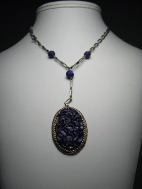 14KT GOLD CARVED LAPIS PENDANT NECKLACE: A necklace consisting of a carved Lapis center stone with a filigree style border connected to chased style rectangular link with three carved Lapis beads set between links. Large Lapis stone is oval,