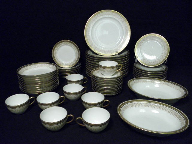 FRENCH L BERNARDAUD & CO GILT PORCELAIN DINNERWARE: L. Bernardaud & Co porcelain dinnerware set. 59 total pieces. France. Gilt rim with detailed geometric pattern. Marked on base "L Bernardaud & Co Limoges, D&Co France". Includes (10) 7.5" bowls, (9) 7