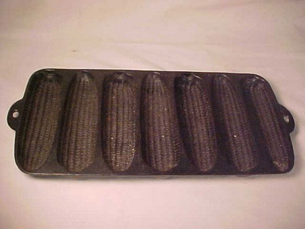 OLD WAGNER WARE CAST IRON CORN BREAD PAN: OLD WAGNER WARE CAST IRON CORN BREAD PAN Measures 15" long by 7" wide. Stamped on reverse, Krusty Korn Kobs, reg in US Pat Off. Wagner Ware Sidney, Pat'd July 6 1920