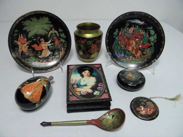 ASSORTED PAINTED RUSSIAN LACQUER WARE ETC: Lot of assorted painted Russian black lacquer ware and more. Includes a paper mache painted spoon, an artist-signed black painted egg display, two porcelain decorative plates, a black decorative box,