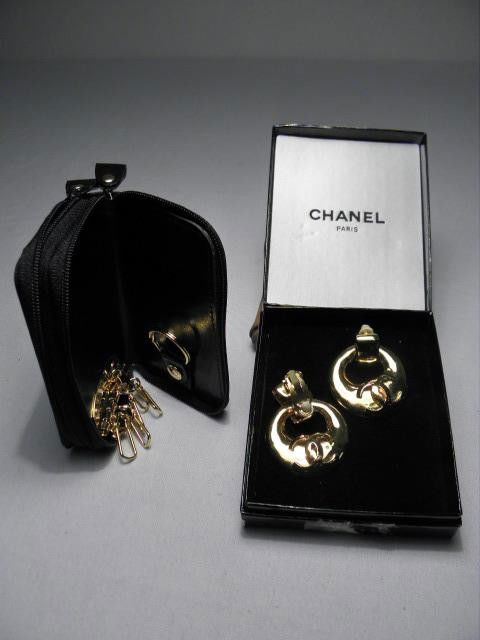 CHANEL FASHION EARRINGS & ST. JOHN KEY CASE: A pair of gold tone Chanel fashion earrings with classic "CC" design, clip on. Sold together with a St. John combination key case and coin purse in black micro fiber. Good condition but for one blemis