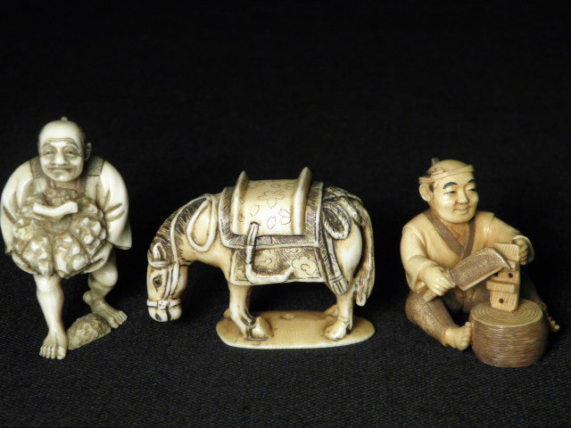 THREE JAPANESE CARVED IVORY NETSUKE: Three Japanese carved ivory netsuke. All three artist signed on base. Includes an elderly man carrying a gourd, a man carving wood, and a horse. Man carving includes a small wooden stand. Condition: s