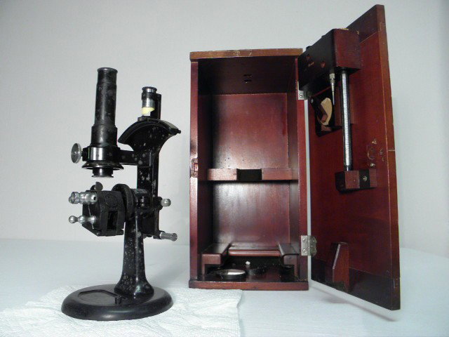 EARLY BAUSCH & LOMB OPTICAL CO IRON MICROSCOPE SET: Early Bausch & Lomb Optical Co iron microscope set. Includes microscope, and wooden case with built in thermometer and vial holders, etc. Label near eye piece reads "Bausch & Lomb Optical Co Rochester