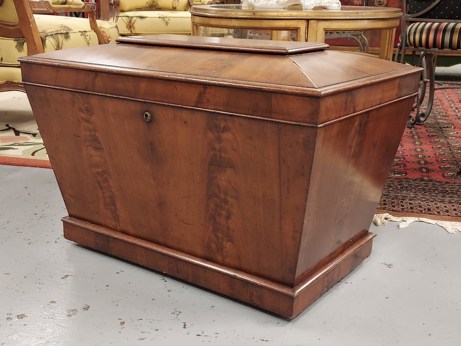 ENGLISH REGENCY MAHOGANY CELLARETTE WINE COOLER: English Regency style mahogany sarcophagus form cellarette or wine cooler. Measures 19" T x 30"W x 19" D. Bookmatched crotch mahogany front. Lead lined. Condition: Small age splits at top. See images.