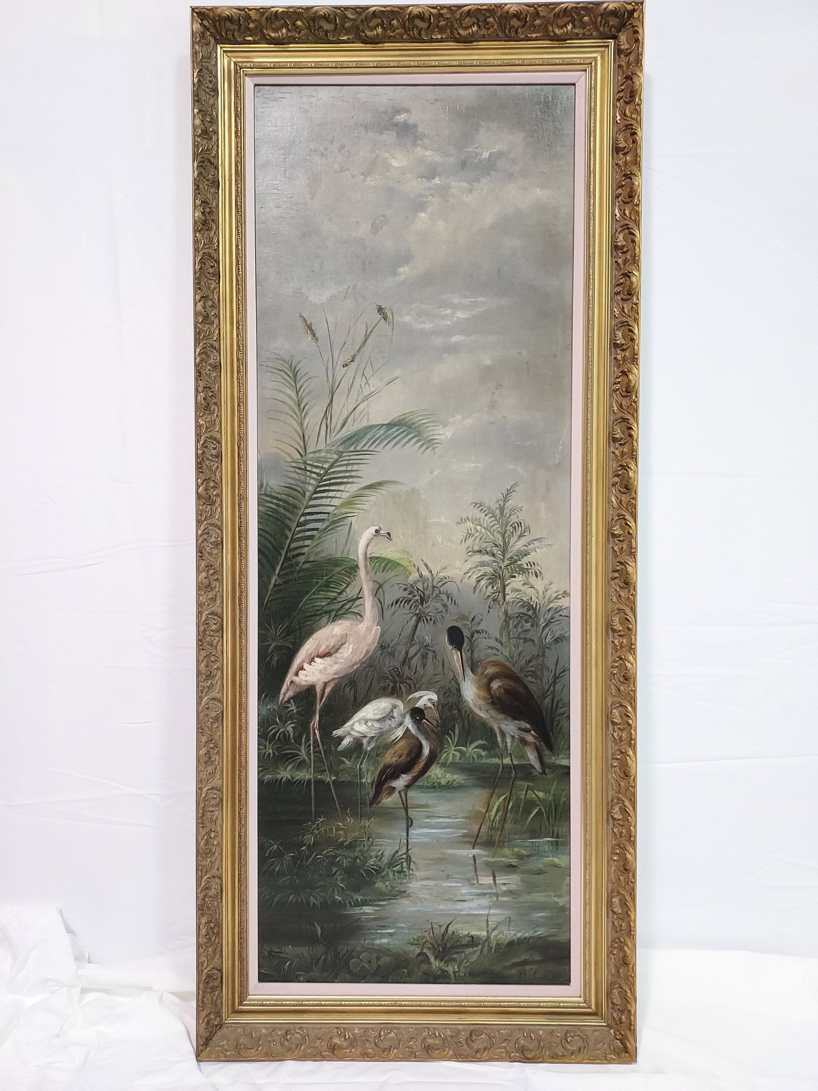EARLY 20TH C OIL ON CANVAS PAINTING: WADING BIRDS: Early 20th century oil on canvas painting depicting four wading birds in a pond. No apparent signature. Measures (frame) 63" tall x 27" wide x 2.25" deep, and (sight) 55.5" tall x 19.5" wide. Conditio
