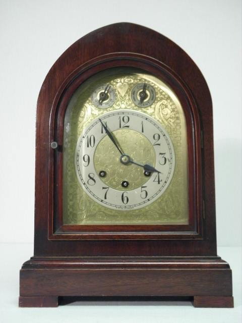 GUSTAVE BECKER MAHOGANY BEEHIVE BRACKET CLOCK: Mahogany bracket clock. Gold toned engraved face with standard arabic numeral numbering, and dials for time, chime/silent, and slow/fast. Westminster chimes. Three winds which all turn. Clock face mar