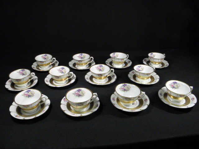 SET OF TWELVE ROSENTHAL PORCELAIN CUPS & SAUCERS: Set of twelve Rosenthal Bavarian porcelain cups and saucers in a floral and gilt pattern. Cups measure 4.5" wide (with handle) x 2.25" tall, and saucers measure 5.75" wide. Each piece is marked on bas