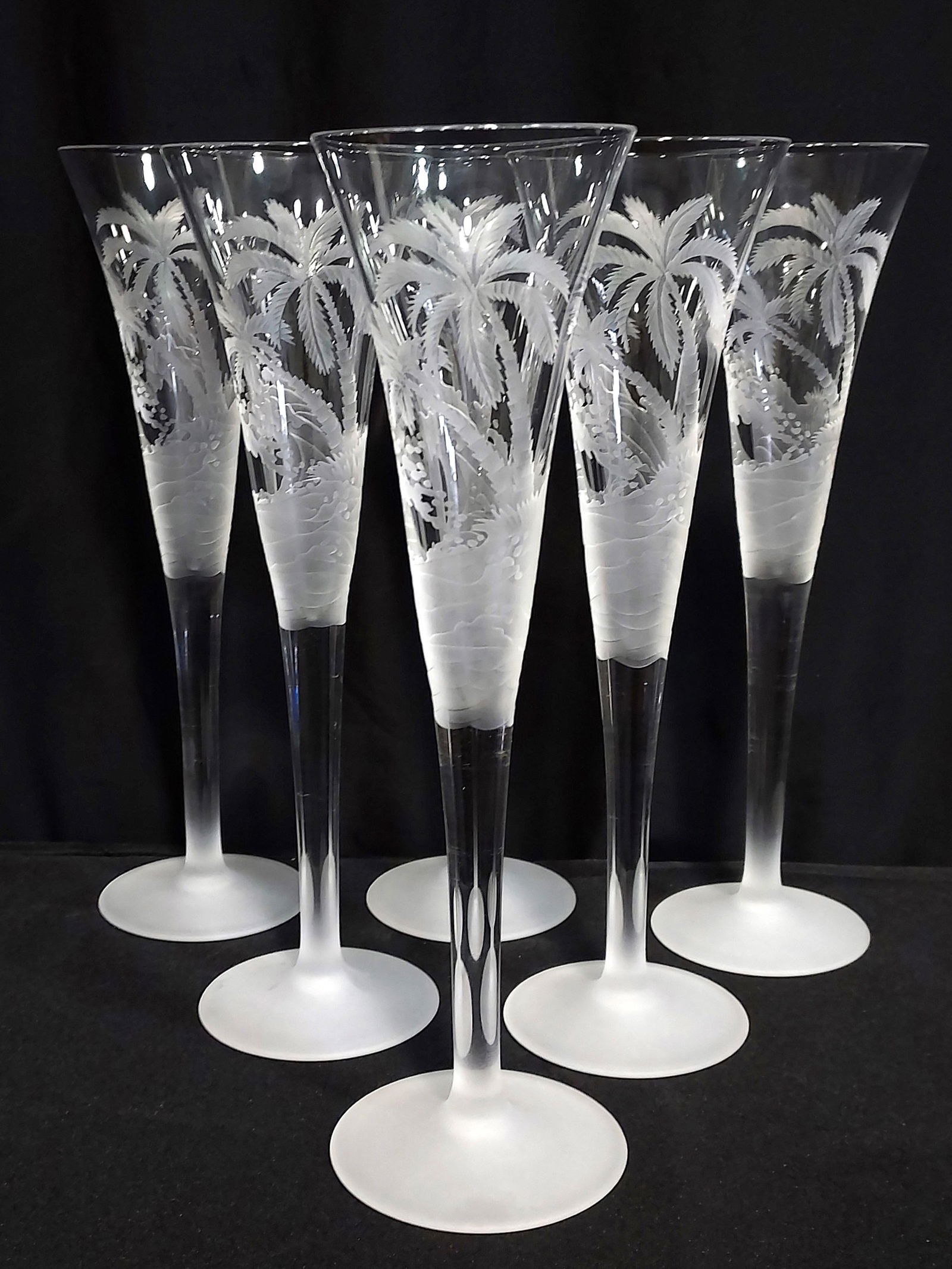 SIX INGRID GLASS ETCHED PALM TREE CHAMPAGNE FLUTES: Six Ingrid Bohemian glass etched champagne flutes with a tropical palm tree motif. Unsigned. Each one measures 11.6" tall. Condition: good, no signs of use, see images. Weight: 5.5 lbs.