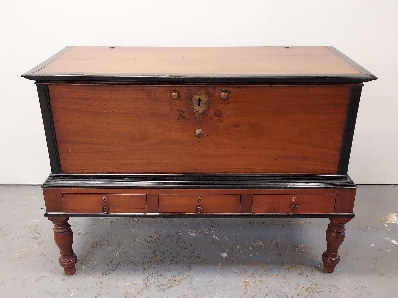 LARGE INDIAN MAHOGANY & EBONY WOOD CHEST ON LEGS: Large Indian mahogany & ebony wood chest on legs with three drawers under the main compartment. Measures a total of 39.5" tall x 55.5" wide and 25" deep. Condition" some minor finish damage and repair