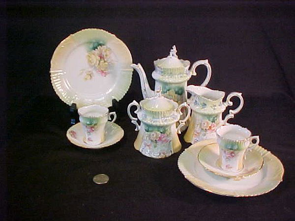 R S PRUSSIA PORCELAIN CHILD'S TEA SET: Tea or Coffee pot measures 6 1/2" tall - lid repaired, chip to rim, Sugar bowl 4 3/4" tall with flake to one point and hairline crack below one handle, Creamer 4" tall with hairline star crack to base