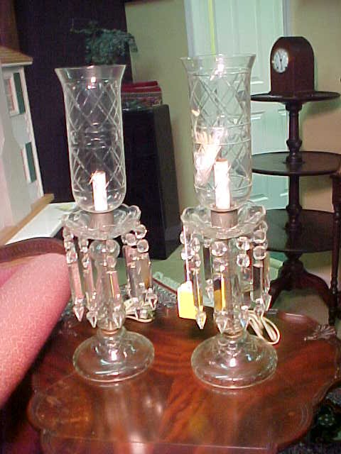 PAIR MANTLE CRYSTAL LUSTER LAMPS PRISMS: Some small chips to shades. Wear to metal fittings. Measure 21 1/2" tall by 7 1/2" wide at base.