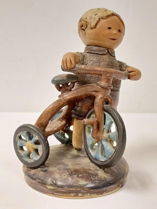 CLIFF STEWART ART POTTERY SCULPTURE: BOY WITH BIKE: Cliff Stewart clay art pottery sculpture of a boy with his tricycle. Signed and dated on base "Cliff Stewart 1966". Measures 7.5" tall x 6" wide. Condition: good, no chips or cracks, no repairs, see i