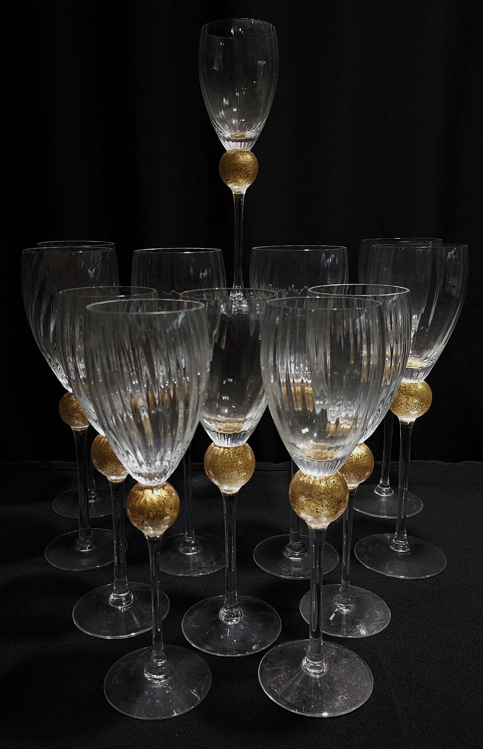UNION STREET GOLD FLECK WINE STEMS BY GUY CORRIE: Twelve Union Street Venetian style art glass wine stems. Clear crystal ribbed cups over a gold flecked sphere and long stem. Each Signed and dated. 2002. Six measuring approx. 10.5" tall x 2.75" wide 