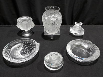 SIX LALIQUE FROSTED CRYSTAL ACCESSORIES: Lot of six Lalique French frosted crystal accessories. Includes a 3.2" tall "Samoa" perfume bottle, a 2.5" tall "Baptiste" perfume bottle, a 5" tall "Chamois" vase, a 3.75" tall "Tete de Lion" cigaret