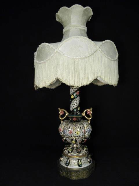 CAPODIMONTE RETICULATED PORCELAIN FLORAL TABLE LAMP: Italian Capodimonte reticulated floral porcelain table lamp. Handled bottle vase-style design, with brass hardware and pierced brass base. Includes large decorative fabric shade with tassels. Conditio