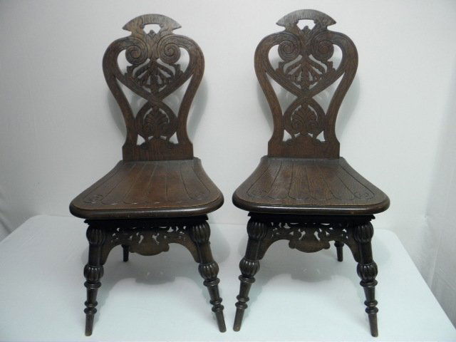 FOUR 19TH CENTURY ENGLISH OAK HALL CHAIRS: Four English oak hall chairs. Circa mid to late 19th century, having carved and incised backs with scroll and feather decoration. Condition: very minor wear to finish, small chip to top corner of one