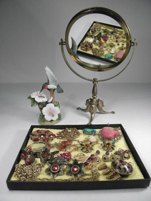 ASSORTED LADIES COSTUME JEWELRY & MORE: VANITY MIR: Lot of assorted ladies costume jewelry plus more. Includes a brass figural table top vanity mirror, a small porcelain figurine of a Hummingbird, various Victorian style and era filigree pins and brooc