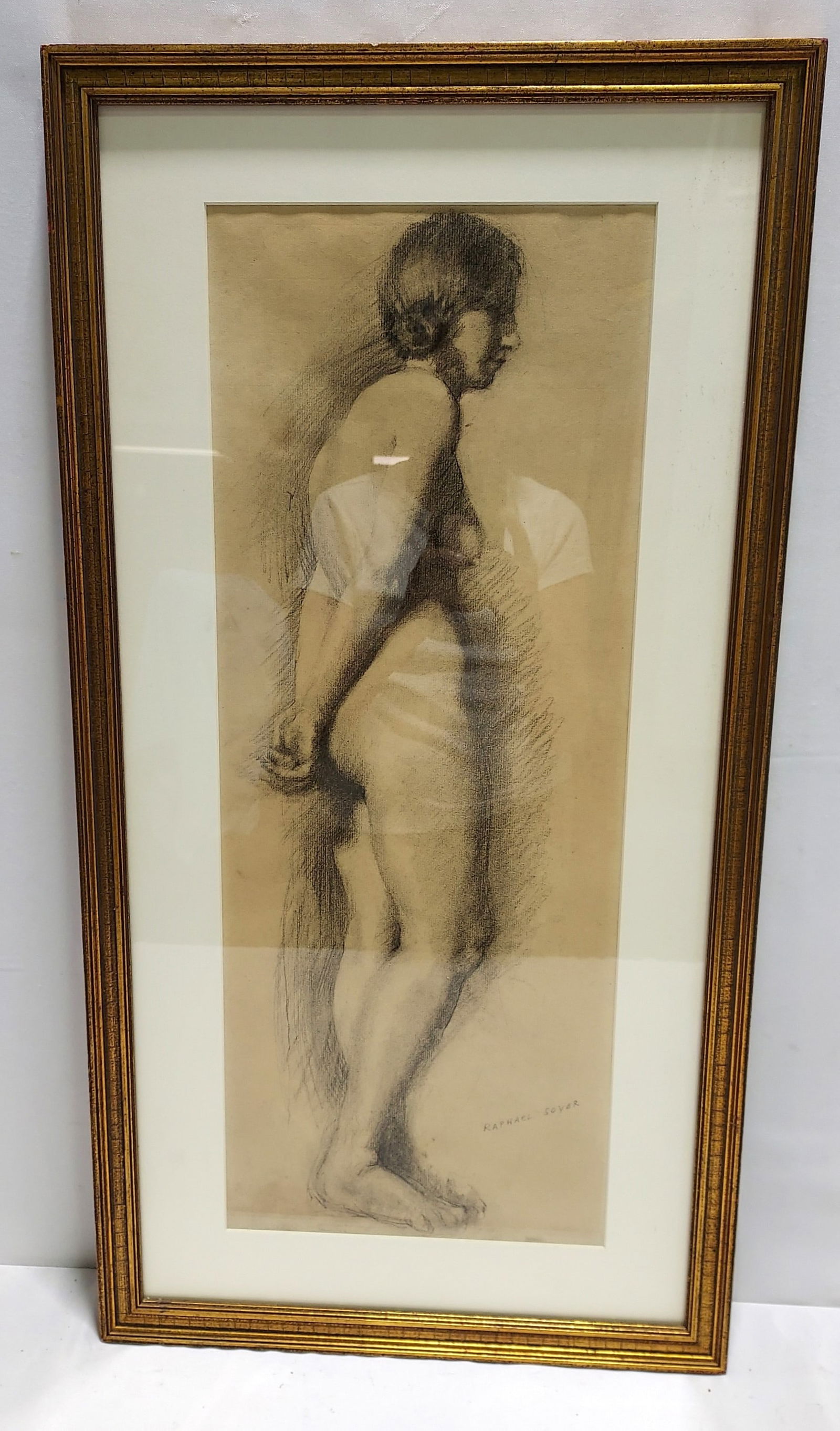 RAPHAEL SOYER CHARCOAL SKETCH ON PAPER: NUDE: Raphael Soyer framed charcoal sketch on paper depicting a standing nude woman. Signed lower right. Measures a total of (frame) 29.5" tall x 15.5" wide, and (sight) 23.5" tall x 9.25" wide. Condition: