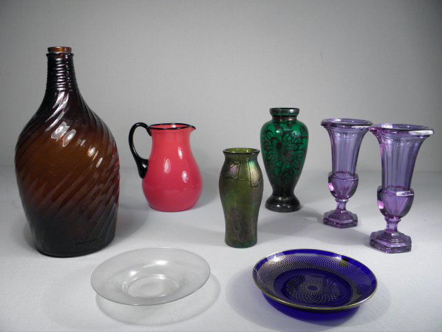 ART GLASS: STEUBEN, CZECHOSLOVAKIA ETC: Lot of eight pieces of assorted art glass. Includes: a 6.4" tall green Loetz type vase, a 6.25" wide iridescent Steuben Verre de Soie plate, a 6.5" Coronaglas gilt cobalt glass plate, an 8.5" silver o