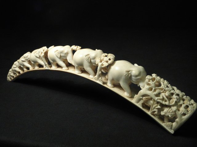 CARVED IVORY ELEPHANT BRIDGE: Carved ivory elephant bridge. Intricately carved monkey, lion, and panther figural group at one end. Condition: early repair to smaller end of bridge, minor discoloration to ivory, see images. Measure