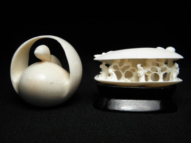 TWO JAPANESE CARVED IVORY NETSUKES: ANABORI & KATA: Two Japanese carved ivory netsuke displays. First depicts a clam shell Anabori netsuke with a miniature figural grouping within, and the second is a Katabori netsuke depicting a swan. Both have small 