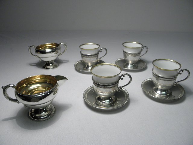 ASSORTED STERLING SILVER TABLEWARES: CARTIER, ETC.: Lot of assorted sterling silver tablewares. Includes 10 total pieces: (4) Cartier sterling silver demitasse cups and saucers with Hutschenruether gold banded porcelain cup inserts, a JWW 2.75" tall we