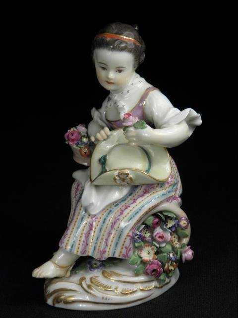 MEISSEN PORCELAIN FIGURE OF A YOUNG GIRL: Meissen hand painted German porcelain figure of a young girl with flowers holding a hat and sitting upon a gilt leaf base. Marked on base of figure with Meissen blue double crossed swords under glaze.