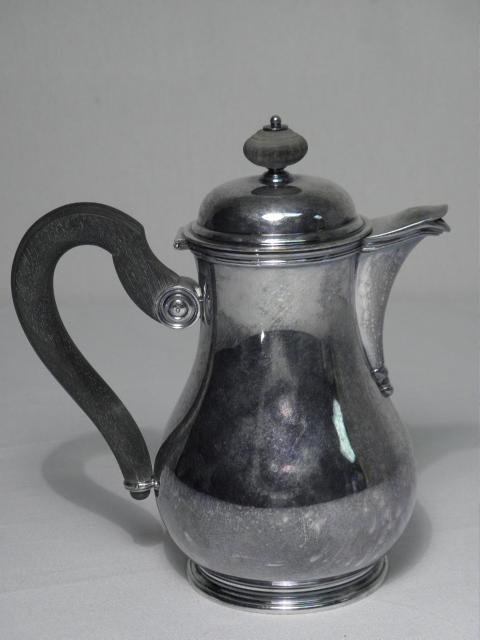 TEZLER SWISS .800 SILVER SYRUP JUG - 12.5 TROY: Tezler Swiss .800 silver syrup jug with an ebonized wood loop handle. Stamped on base "800 Tezler 32-11". Condition: dent to base rim, minor dings, see images. Measures 6.5" tall x 6" handle to spout.
