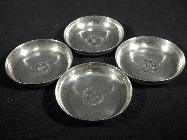 FOUR MIDDLE EASTERN COIN MOUNTED SILVER DISHES - 4: Lot of four Middle Eastern coin mounted silver dishes with engraved outer rims. Unmarked, but tests positive for silver. Condition: very minor tarnishing, see images. Each dish measures 3" in diameter