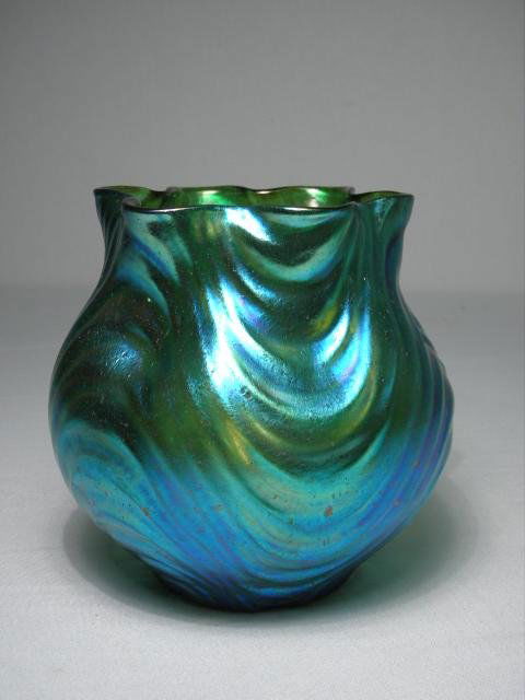 EARLY 20TH C LOETZ WELLENOPISCH ART GLASS VASE: A late 19th/early 20th century Loetz "Wellenopisch" iridescent art glass vase with pulled sides and a ruffled rim. Green/blue transparent glass with extra fine iridescent finish, unsigned. Condition: