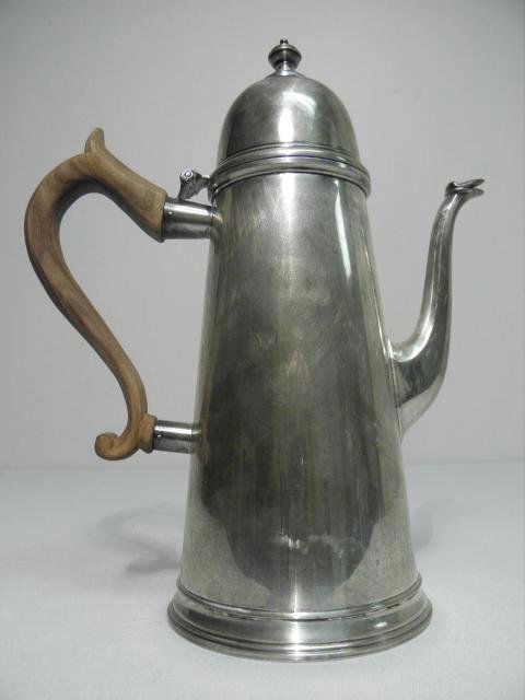 JAMES ROBINSON STERLING SILVER COFFEE POT: James Robinson sterling silver coffee pot. George I style, with a wooden handle and fixed spout. Stamped on base "James Robinson Sterling 1102 L". Condition: very minor tarnishing, small dent to back