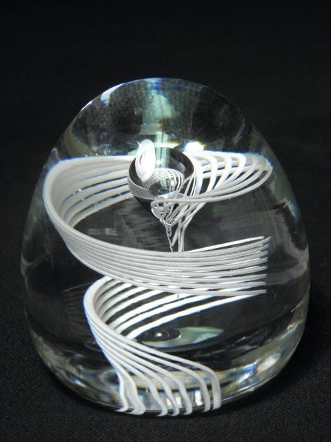 STEUBEN ART GLASS "CANE" PAPERWEIGHT: Steuben art glass paperweight titled "Cane". Features eight twisting swirled white lines within a glass globes, and with a controlled bubble in the center. Designed by George Thompson in 1952, signed 