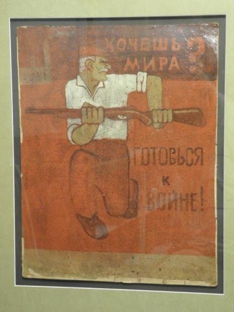 HAND PAINTED RUSSIAN WAR PROPAGANDA POSTER: "WANT : A hand painted and glazed Russian war propaganda poster. Framed, matted, and under glass in a plaster cream colored frame. "Want Peace? Prepare for War" in Cyrillic. Signed illegibly lower left, with 
