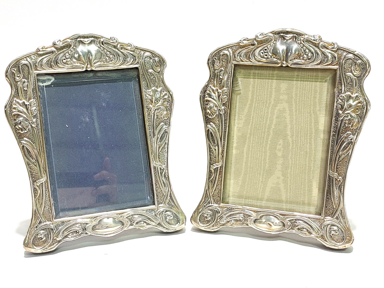 PR ART NOUVEAU STERLING SILVER & WOOD PHOTO FRAMES: Pair of English Art Nouveau period sterling silver overlay on wood photo frames by Horton & Allday. Wood backing / frame with repousse sterling fronts and beveled glass. Each one measures a total of 8