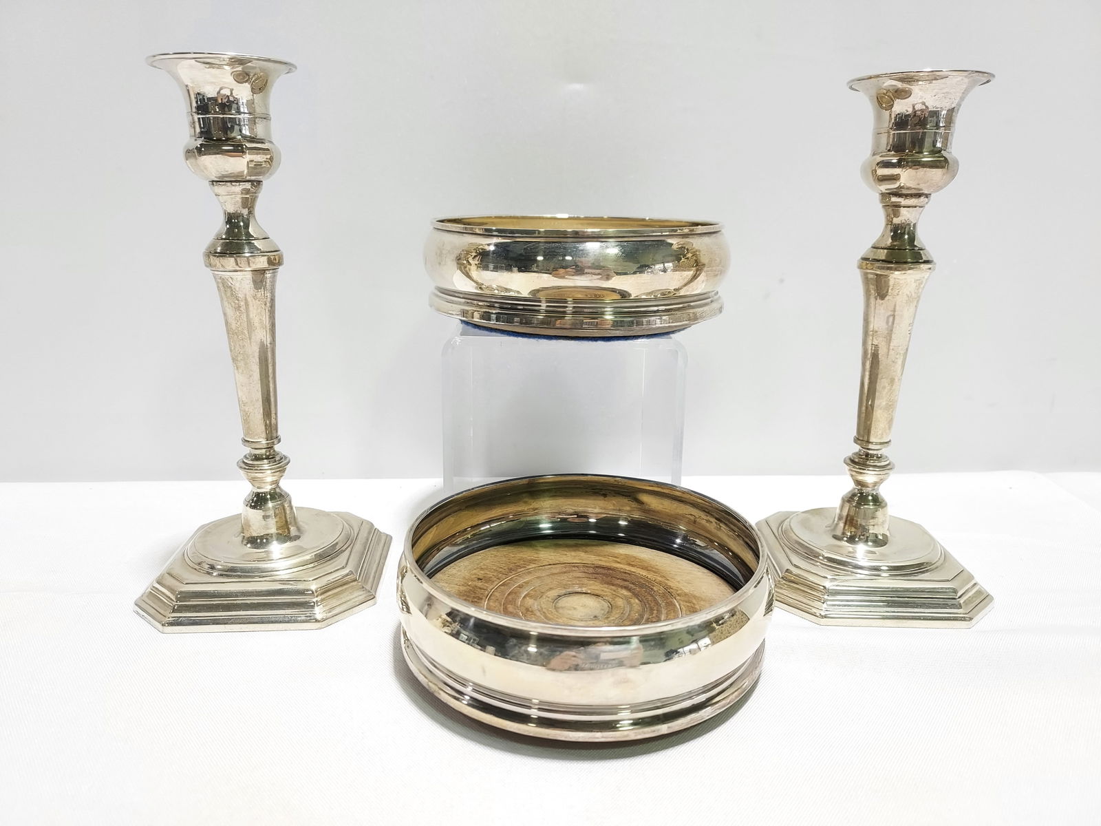 ESTATE SILVER CANDLESTICKS & WINE COASTERS 14t+: Lot including a pair of solid .800 silver 7.75" candlesticks (unknown makers mark - "G" within a diamond within an oval), along with a pair of 1971 London sterling silver and wood wine coasters (5.25"