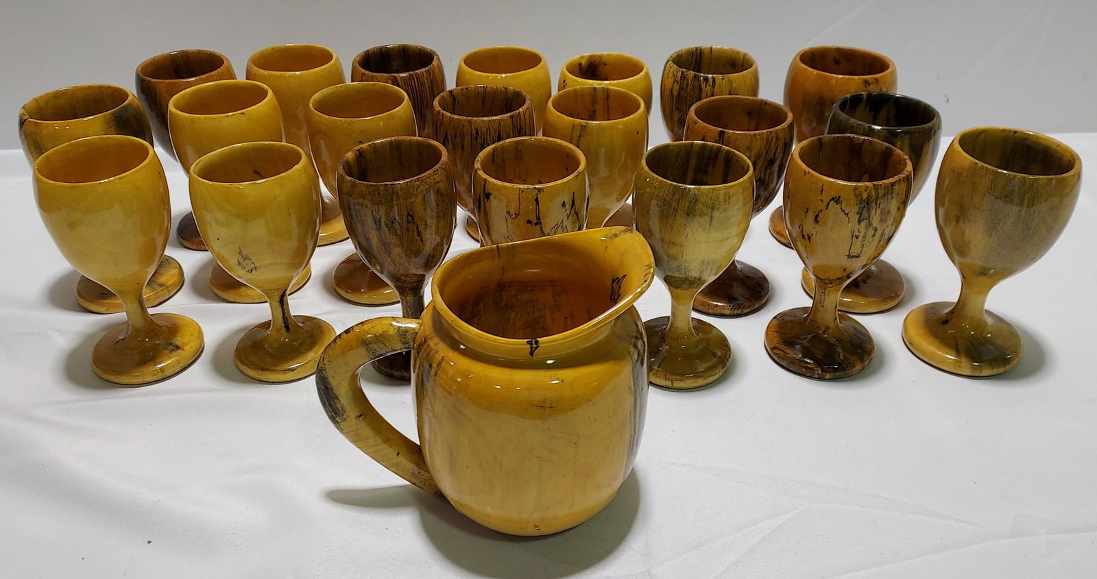 H2052 Blond / Black wood Goblets & Pitcher 22 pc: Blond / Black wood Goblets & Pitcher 22 pc. 21 light wood goblets and one pitcher. Artistically created with black highlights to look like spated maple. Goblets 7" x 3", Pitcher is 8" x 10 to handle.