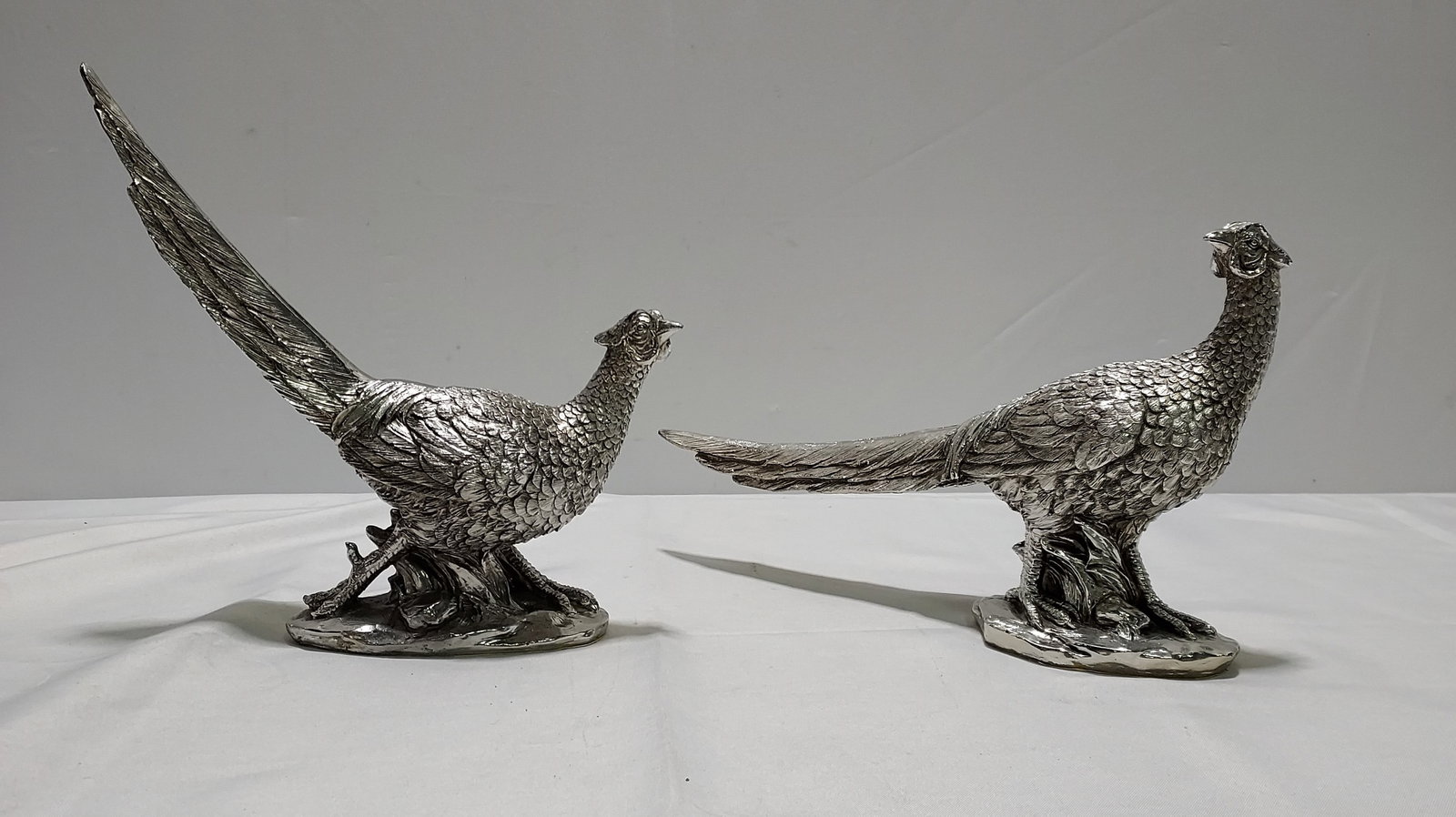 H106 A pair of decorative Pheasants: Vintage pair of silver foil over resin walking pheasants by Regency. .12" x 12" x 3 and 8.5" x 15" x 3"