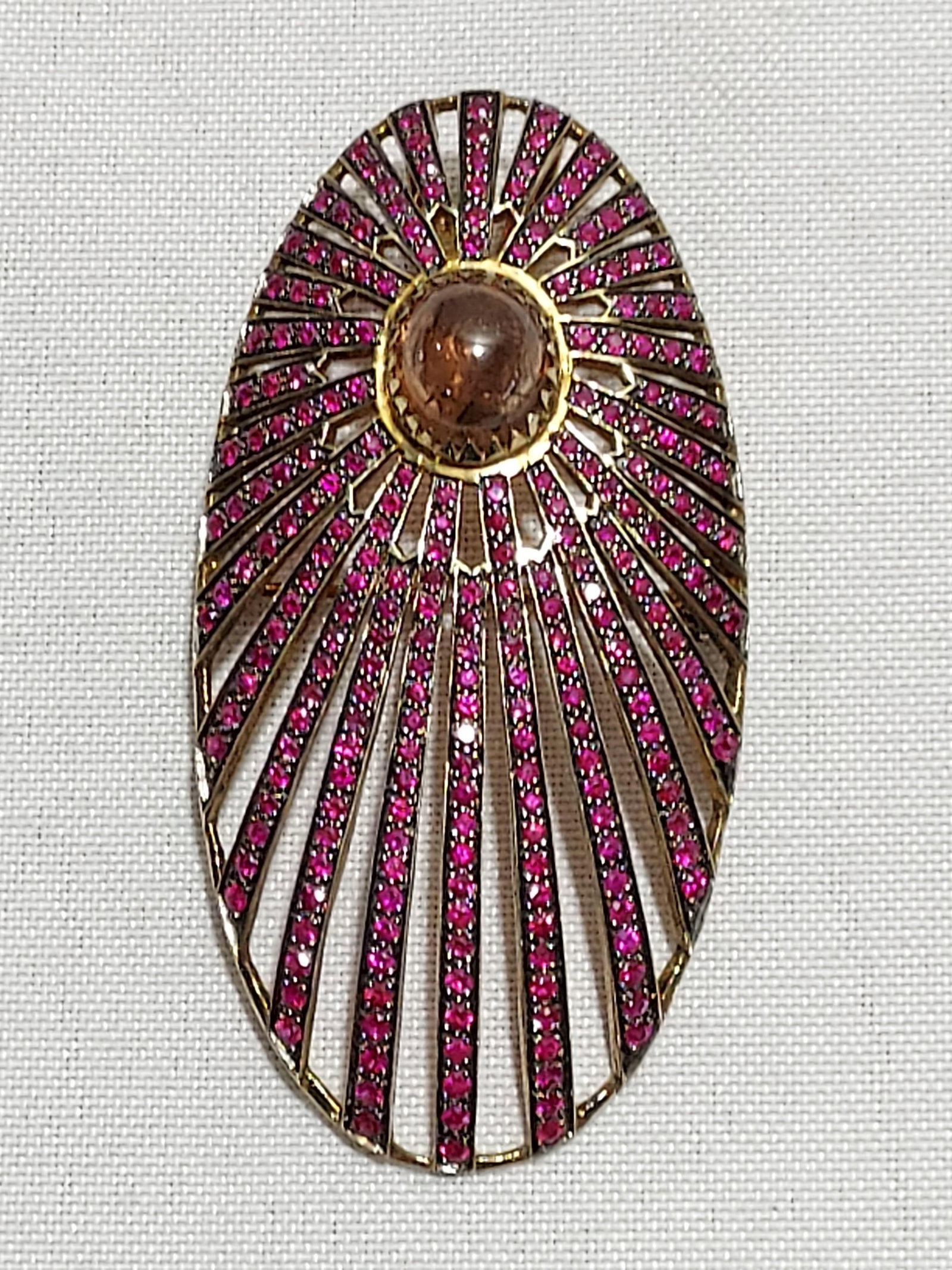 HJ186 Gold plated pink sapphire/tourmaline brooch: Gold plated silver pink sapphire and cabochon tourmaline brooch/pendant: oval starburst pendant set with pink sapphires and a tourmaline cabochon. Approx. 2.75" tall and 1.5" wide. Weight 21.8 grams